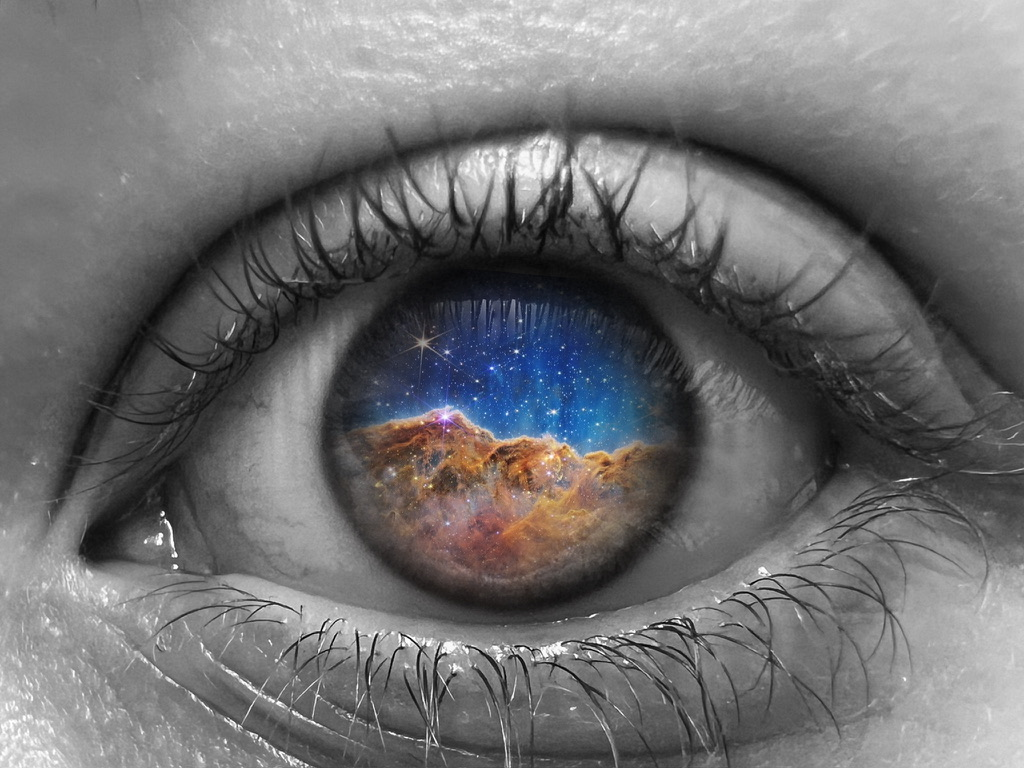 close up of a monochrome eye with an orange and blue galaxy replacing the iris and pupil.